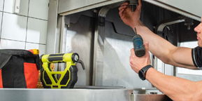 Technician inspecting the interior of an kitchen exhaust system